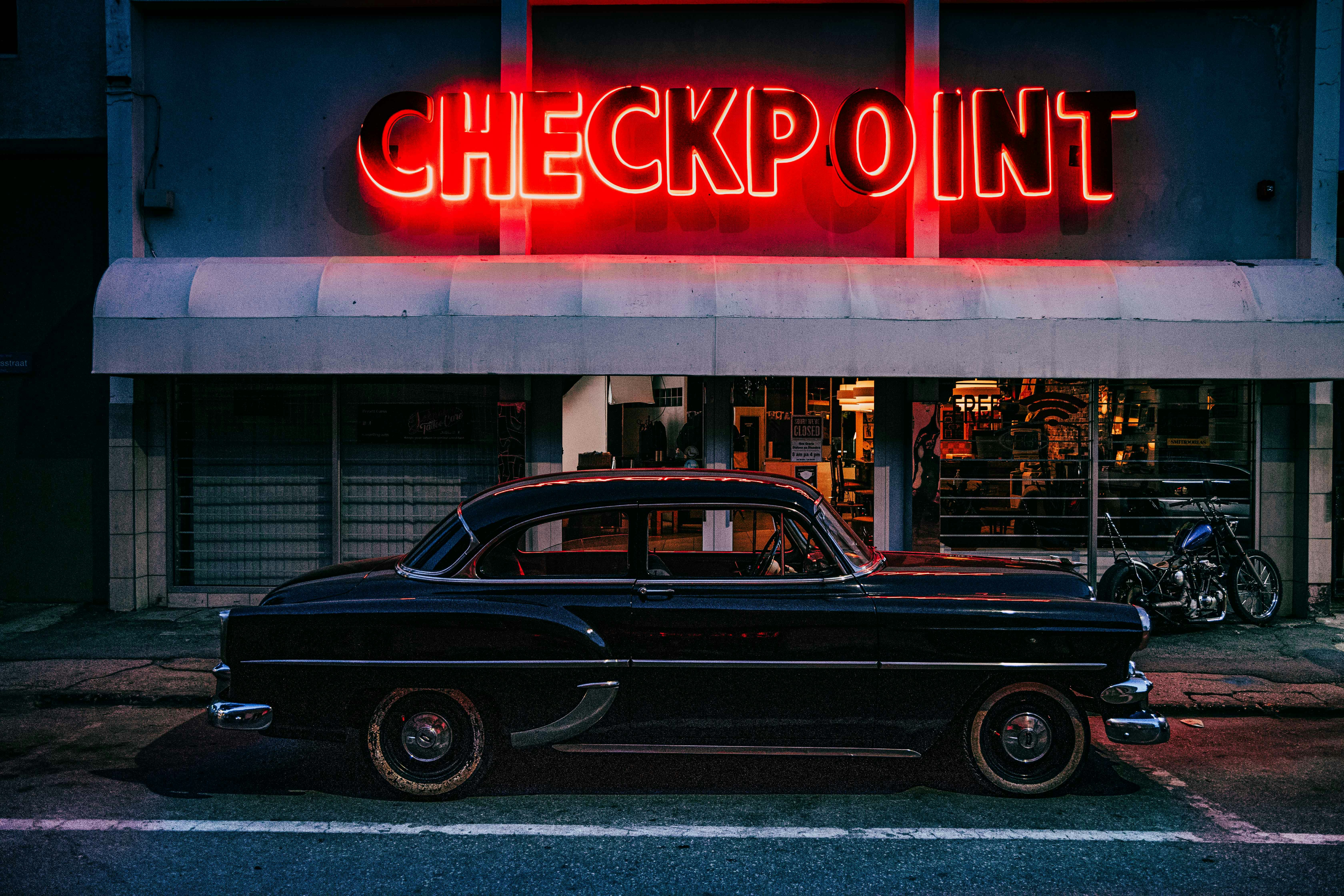 black classic car parked near red and white UNKs store